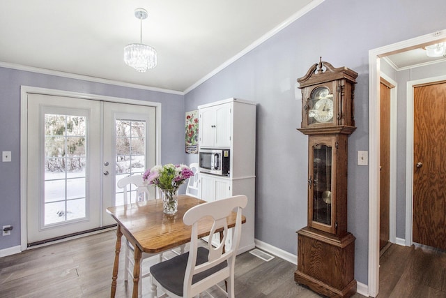 dining room with hardwood / wood-style floors, crown molding, french doors, and a healthy amount of sunlight