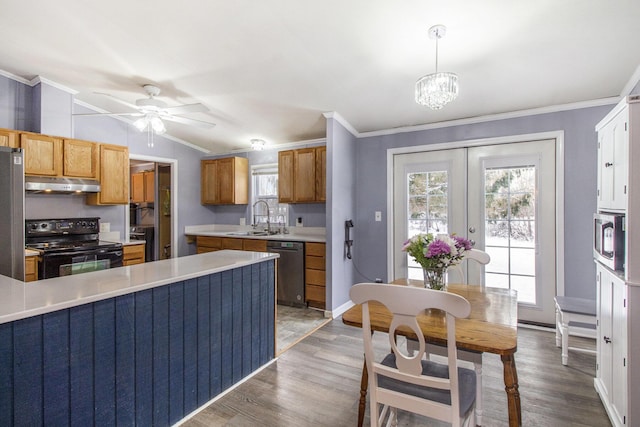 kitchen featuring black appliances, crown molding, sink, pendant lighting, and lofted ceiling