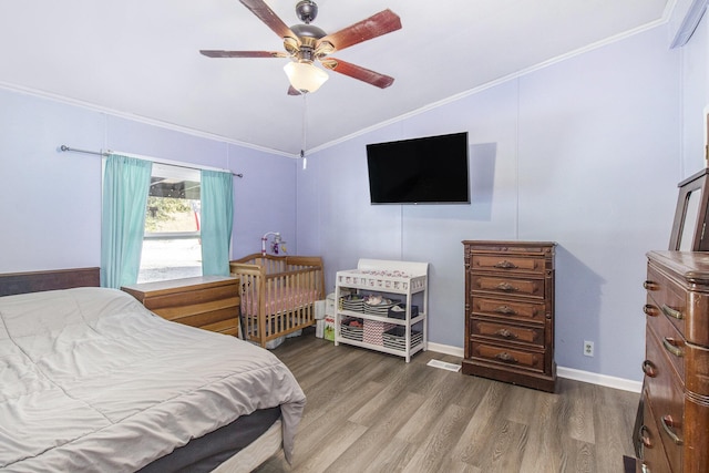 bedroom with ceiling fan, hardwood / wood-style floors, crown molding, and vaulted ceiling