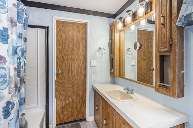 bathroom featuring shower / bath combo with shower curtain and vanity