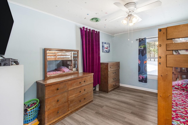 bedroom with ceiling fan, hardwood / wood-style floors, and ornamental molding