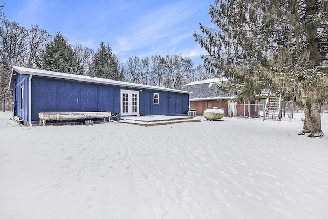 snow covered property featuring french doors