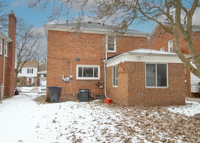 snow covered house with central air condition unit