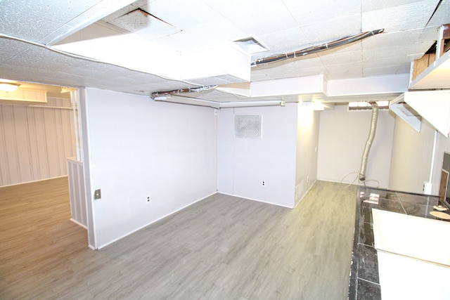 basement with hardwood / wood-style flooring