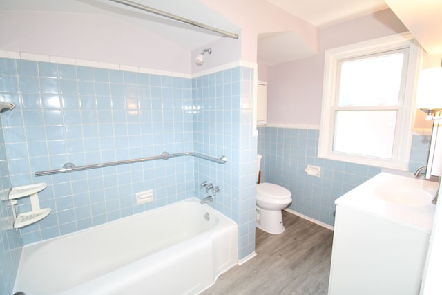 full bathroom featuring toilet, bathing tub / shower combination, hardwood / wood-style flooring, tile walls, and vanity