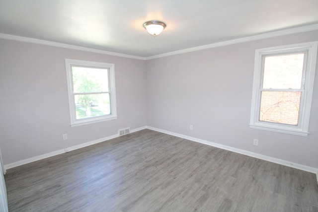 spare room featuring wood-type flooring and ornamental molding