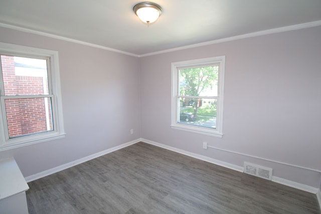 spare room featuring dark hardwood / wood-style flooring and ornamental molding