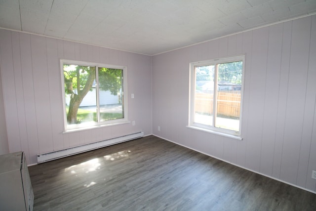 empty room with a baseboard radiator, wooden walls, and dark hardwood / wood-style flooring