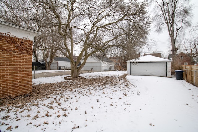 snowy yard with an outbuilding and a garage