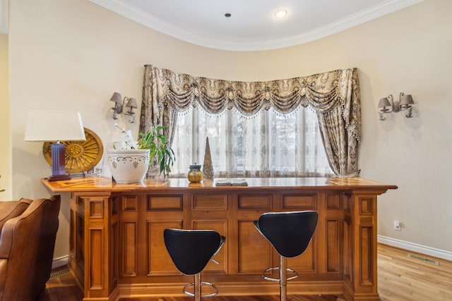 bar featuring crown molding and light wood-type flooring