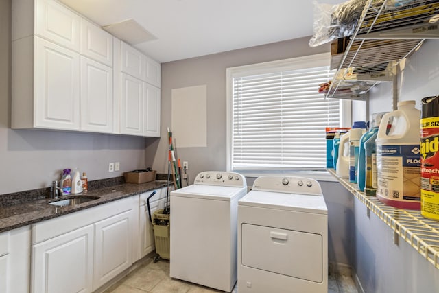 laundry area featuring sink, washing machine and clothes dryer, light tile patterned floors, and cabinets