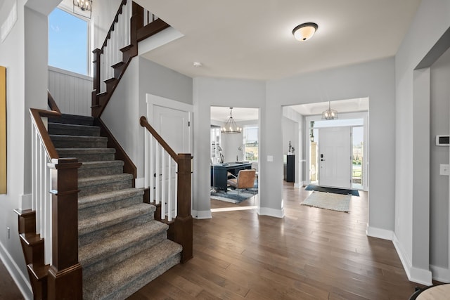 entrance foyer featuring an inviting chandelier and dark hardwood / wood-style floors