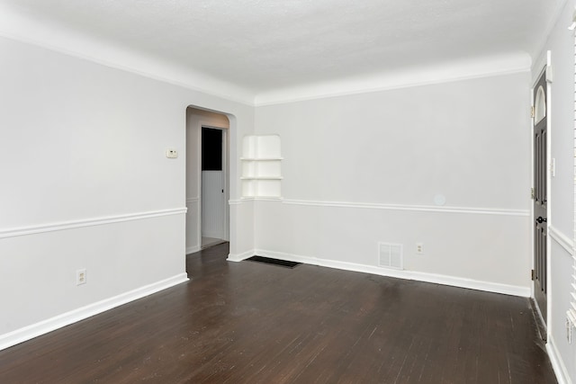 spare room featuring ornamental molding and dark hardwood / wood-style flooring