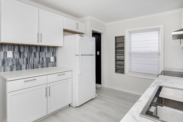 kitchen featuring white cabinets, white refrigerator, ornamental molding, and tasteful backsplash