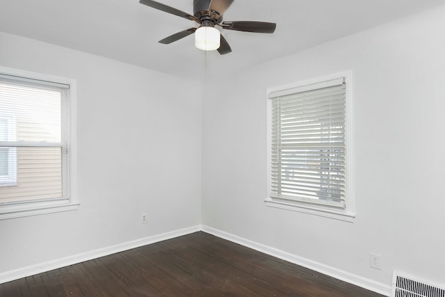 empty room featuring ceiling fan, plenty of natural light, and dark hardwood / wood-style flooring