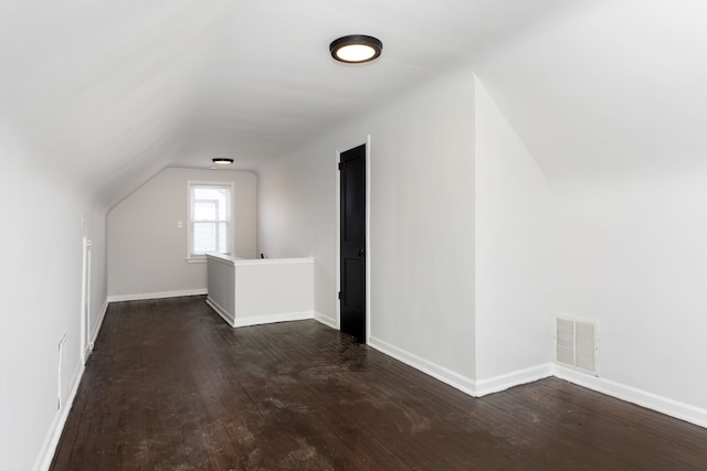 additional living space with vaulted ceiling and dark wood-type flooring