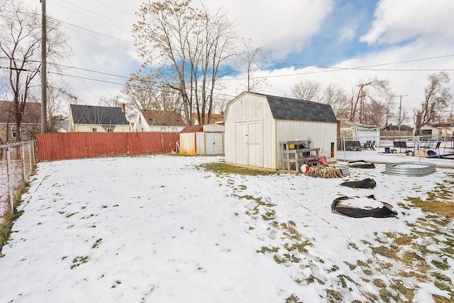 yard covered in snow featuring a storage shed