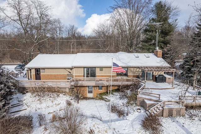 snow covered house featuring a deck