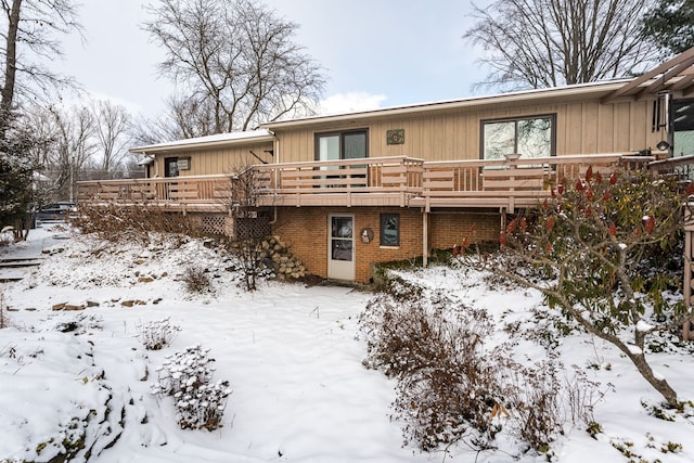 snow covered property with a wooden deck