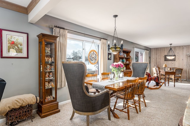 dining area with beamed ceiling, carpet flooring, and wooden walls