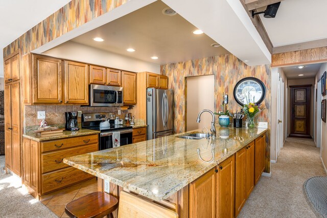 kitchen with tasteful backsplash, sink, a kitchen bar, light colored carpet, and stainless steel appliances