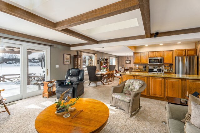 carpeted living room with beamed ceiling