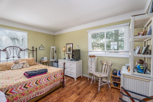 bedroom with ornamental molding and dark hardwood / wood-style floors