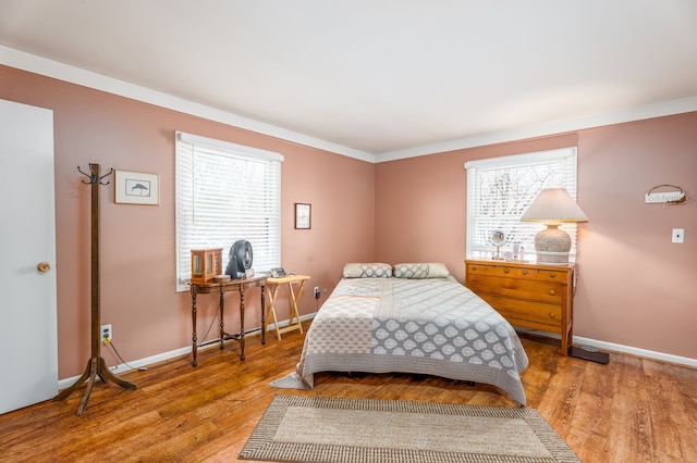 bedroom with ornamental molding and hardwood / wood-style floors