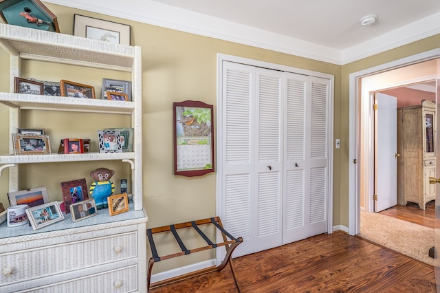 interior space featuring ornamental molding, dark hardwood / wood-style flooring, and a closet