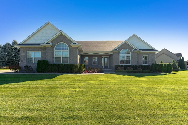 craftsman inspired home featuring brick siding and a front yard