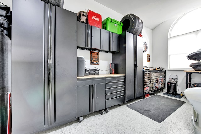 kitchen with freestanding refrigerator, light speckled floor, and gray cabinetry