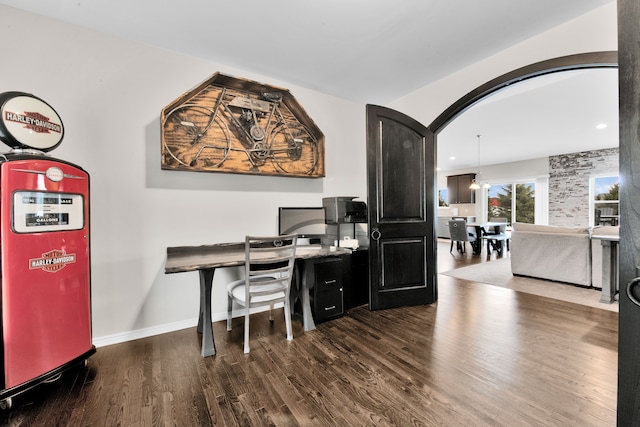 office space with arched walkways, dark wood-style flooring, and baseboards