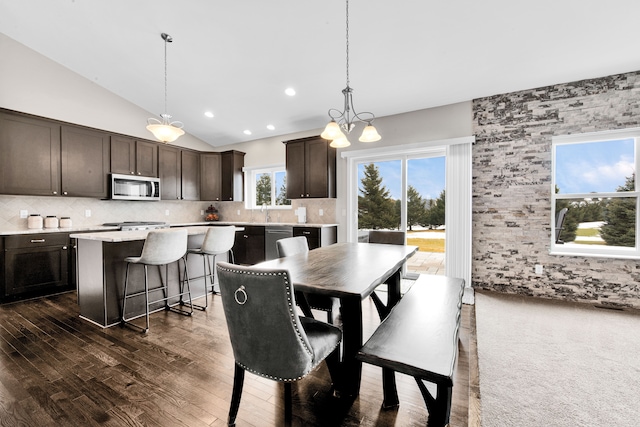 dining room with lofted ceiling, dark wood-type flooring, and recessed lighting