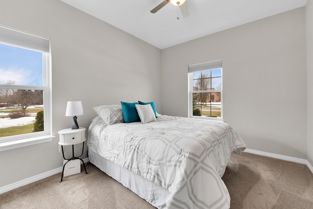 carpeted bedroom with a ceiling fan and baseboards