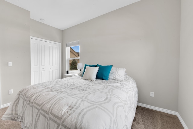 carpeted bedroom featuring a closet and baseboards