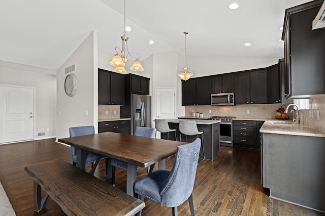 dining space featuring dark wood-style floors, high vaulted ceiling, and visible vents