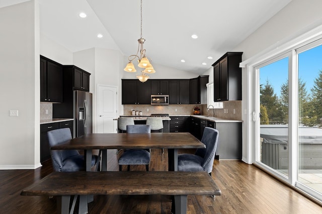 dining area with vaulted ceiling, recessed lighting, wood finished floors, and a chandelier