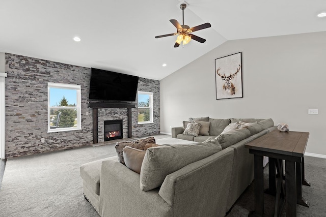 carpeted living area featuring recessed lighting, vaulted ceiling, a ceiling fan, and a stone fireplace