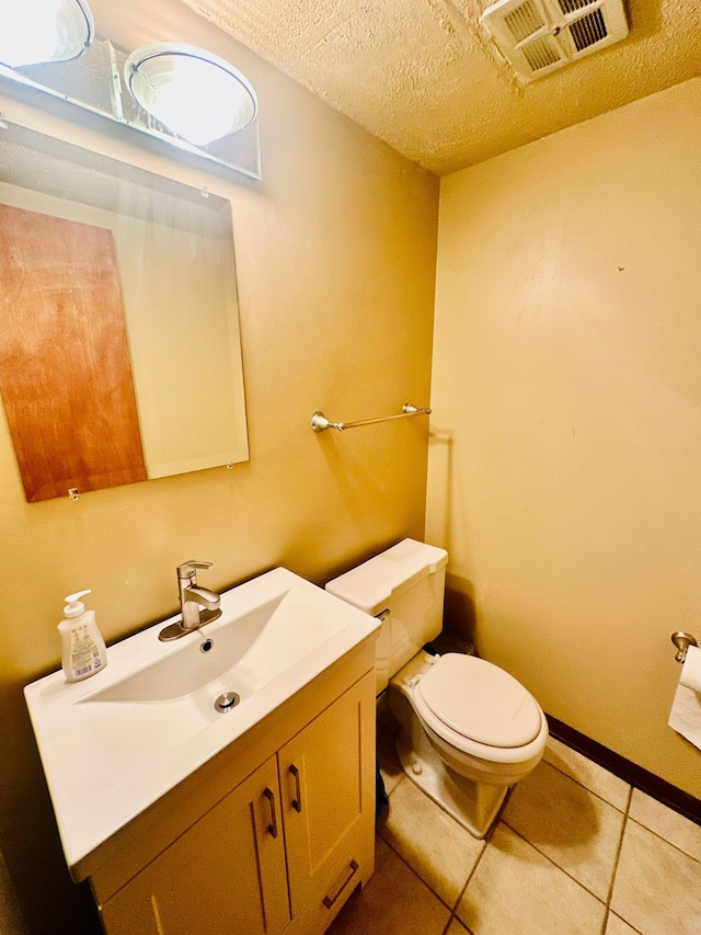 bathroom featuring toilet, a textured ceiling, tile patterned floors, and vanity