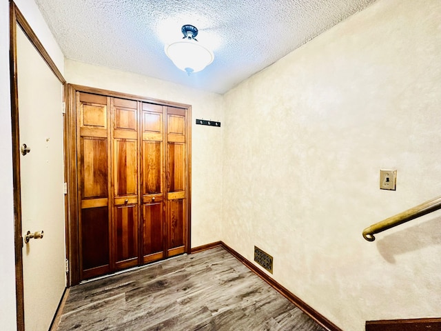 foyer featuring hardwood / wood-style flooring and a textured ceiling