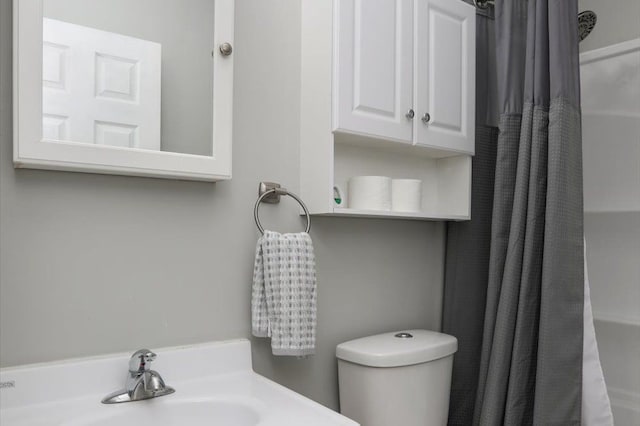 bathroom featuring sink, a shower with curtain, and toilet