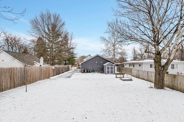 snow covered back of property featuring a storage shed