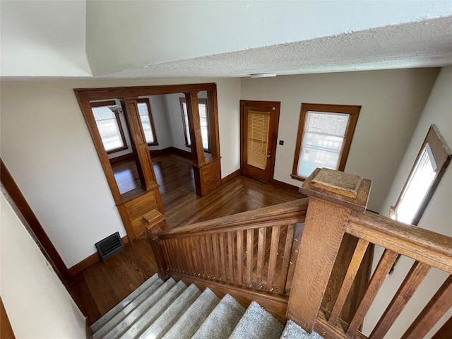 staircase with a healthy amount of sunlight and wood-type flooring