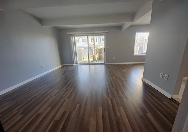 empty room featuring beam ceiling and dark hardwood / wood-style flooring