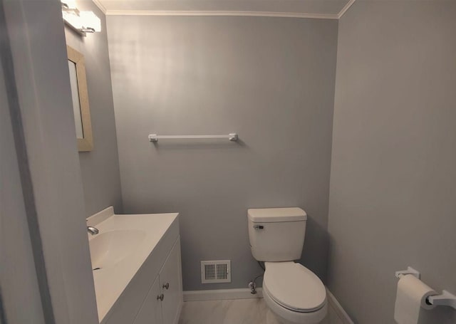 bathroom with vanity, toilet, and crown molding