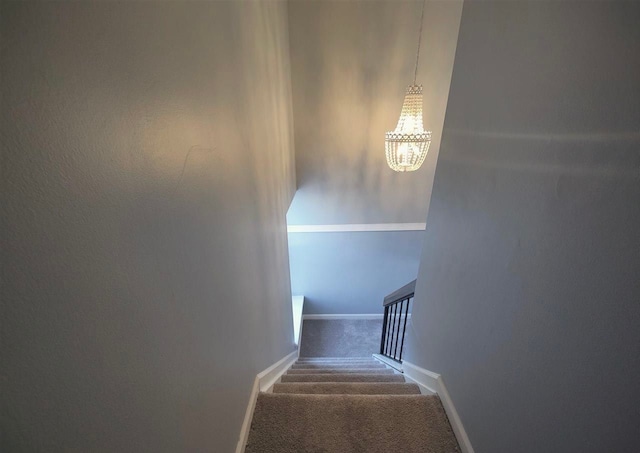 staircase featuring a notable chandelier