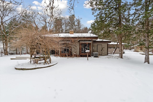 snow covered house with central AC unit