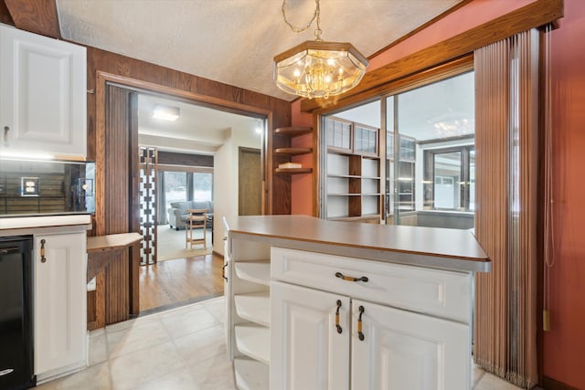 kitchen with hanging light fixtures, white cabinets, and black dishwasher