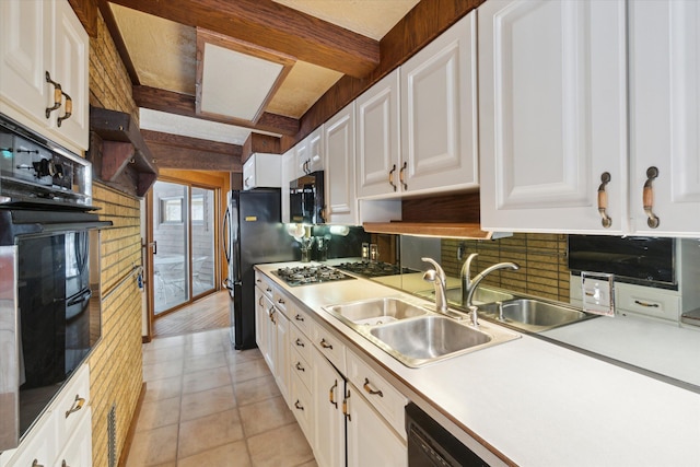 kitchen featuring white cabinets, beam ceiling, tasteful backsplash, and sink