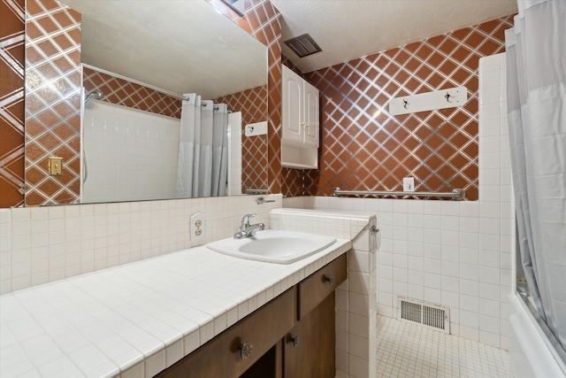 bathroom with vanity, tile walls, and shower / tub combo with curtain